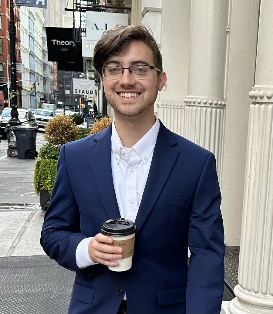 Dylan McLane on a SoHo street in New York, holding a coffee